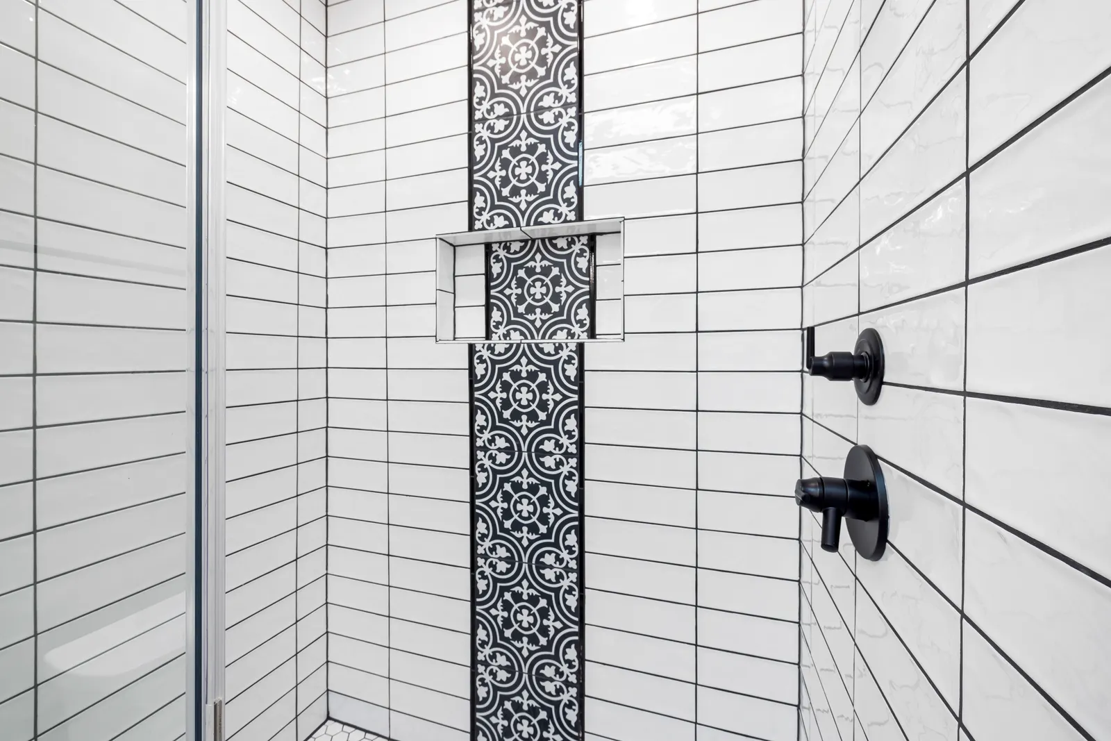 Chrome tile trim finishing a shower niche